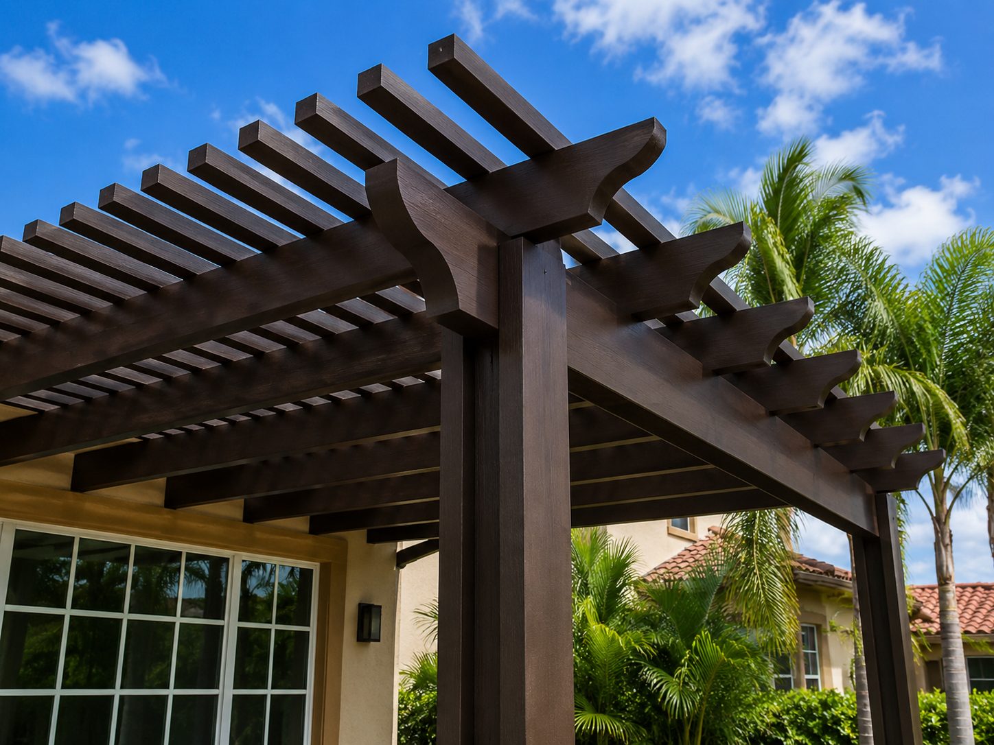 Close view of the shaped rafter tails and corbels on a dark bronze aluminum pergola
