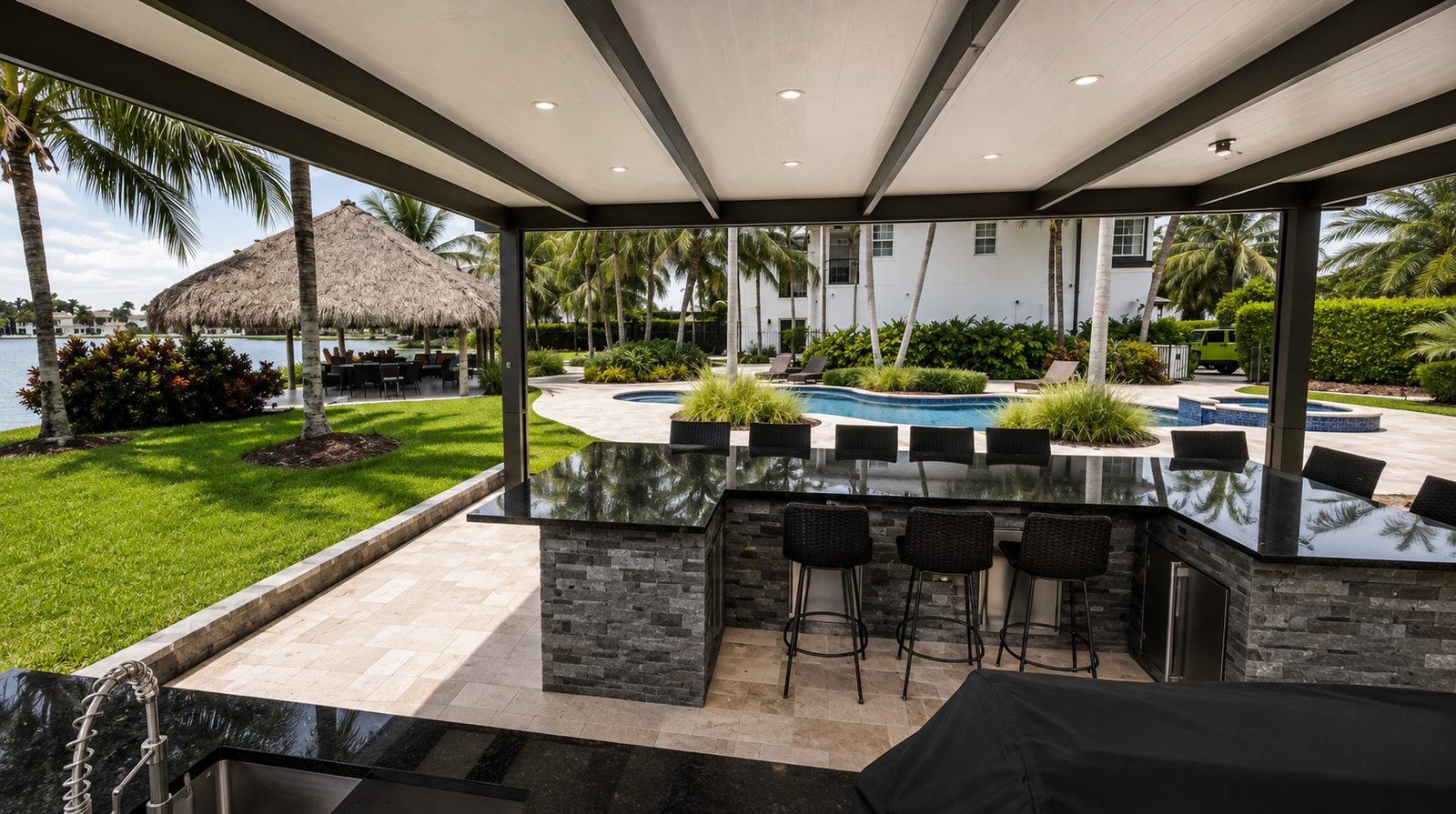 View from under a bronze aluminum patio cover with recessed lighting over a granite outdoor bar overlooking a lake